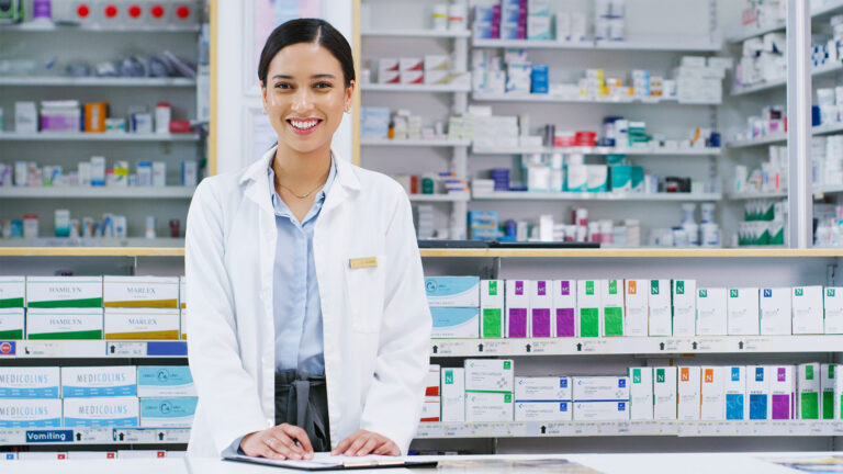 Pharmacy professional standing at pharmacy counter.