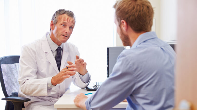 Pharmacist talking to patient at a desk