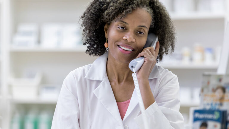 Pharmacy professional talking on the phone in the pharmacy.