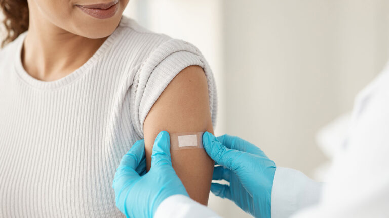 Pharmacist applying a bandage to a patient's arm