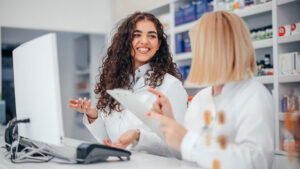 Two pharmacy professionals working together at the computer