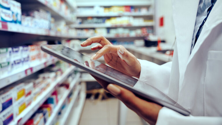 Close up of pharmacy professional using tablet computer in the pharmacy