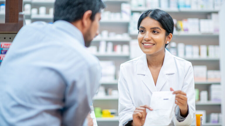 Pharmacy professional in the pharmacy helping patient