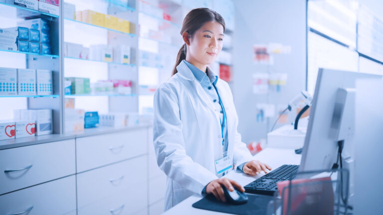 Pharmacy professional working on computer in the pharmacy.